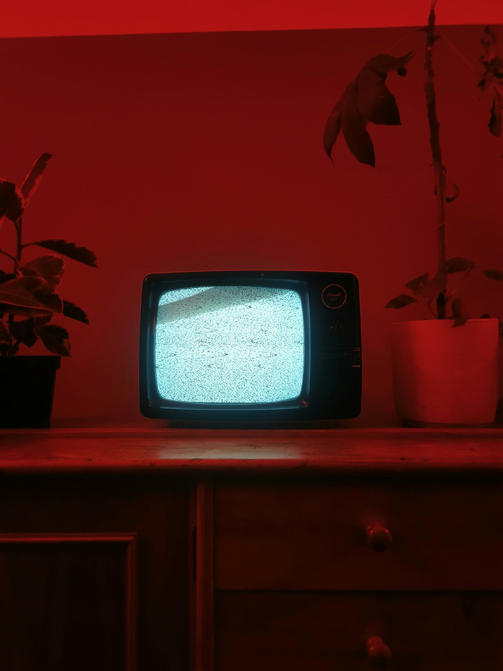 Oude beeldbuis-tv met ruis op een houten kast